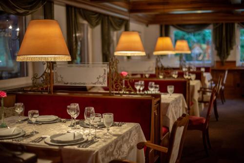 un restaurante con mesas con copas de vino y lámparas en Hotel Ritta Höppner, en Gramado