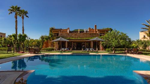 a large swimming pool in front of a house at L'OLIVERAIE DE L'ATLAS in Marrakesh