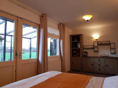 a bedroom with a bed and a large window at B&B Usselo Klein, fijn en uniek! in Enschede