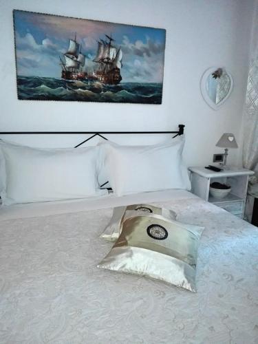 Un dormitorio con una cama blanca con un cuadro en la pared. en HARMONY HOUSE, en Calcara