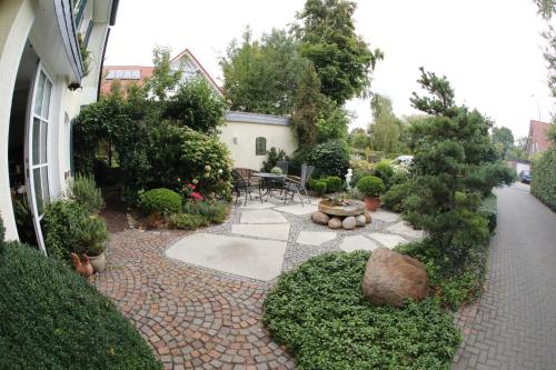 a garden with a patio with a table and chairs at Gästehaus Niemerg in Warendorf