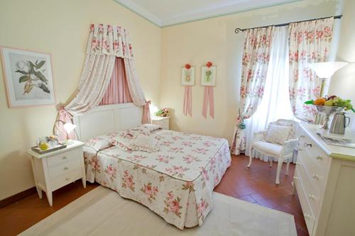 a bedroom with a bed and a dresser and two windows at Tenuta Quadrifoglio in Gambassi Terme