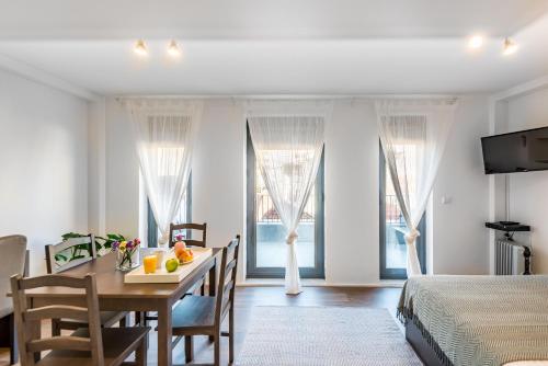 ポルトにあるSamasal Trindade Apartmentsのダイニングルームテーブルとベッドルーム1室が備わります。