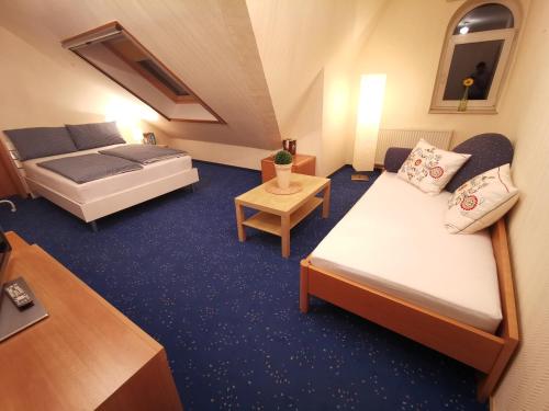リンテルンにあるWunderschöne Landhauswohnung in Rintelnのベッド2台とテーブルが備わる小さなホテルルームです。