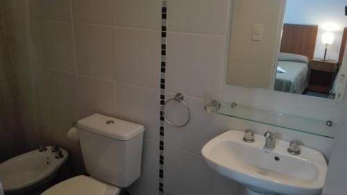 a bathroom with a toilet and a sink and a mirror at Hotel Caribe in Mar del Plata