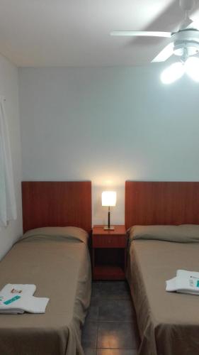 two beds in a room with a ceiling fan at Hotel Caribe in Mar del Plata