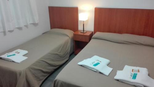 two beds sitting next to each other in a room at Hotel Caribe in Mar del Plata
