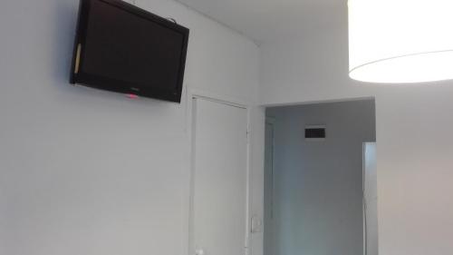 a flat screen tv hanging on a white wall at Hotel Caribe in Mar del Plata
