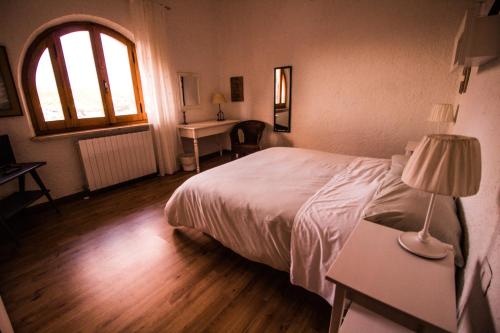 a bedroom with a bed and a desk and a window at Casa sui Tetti in Ozieri
