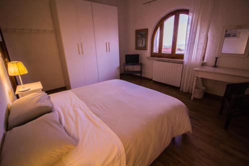 a bedroom with a large white bed and a window at Casa sui Tetti in Ozieri