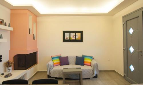 a living room with a couch and a tv at Viglaki House in Naxos Chora