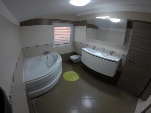 a bathroom with a tub and a sink and a toilet at Apartments Akacijev Izvir in Miklavž na Dravskem Polju