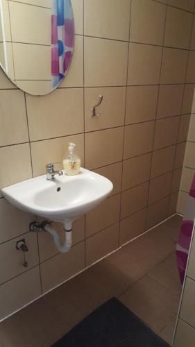 bagno con lavandino bianco e specchio di Pensiunea Ioana a Borlova