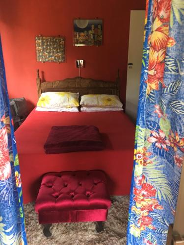 a bedroom with a bed and a red wall at Loft Cravo & Canela in São Pedro da Serra