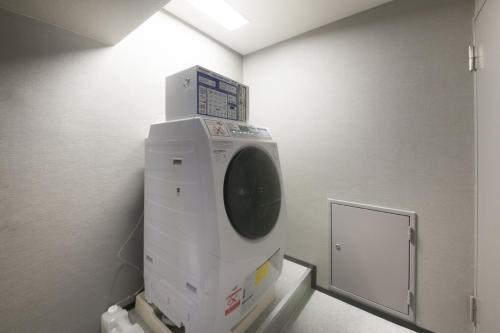 a washing machine in a room with a mirror at Center Hotel Tokyo in Tokyo