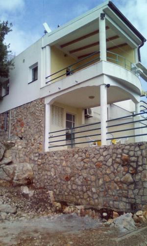 ein Gebäude auf einer Steinmauer in der Unterkunft Apartments Nenadić in Utjeha