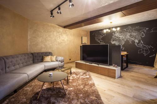 a living room with a couch and a large television at Bella Roe Premium Apartments in Belgrade