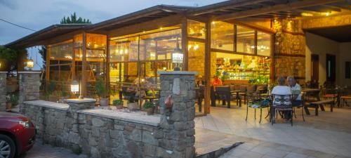 a restaurant with people sitting in chairs outside of it at Spitiko in Kato Loutraki