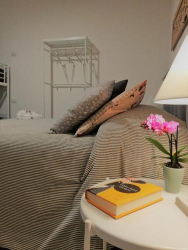 a bed with pillows and a table with a book at B&B Casa Lilli in Foligno