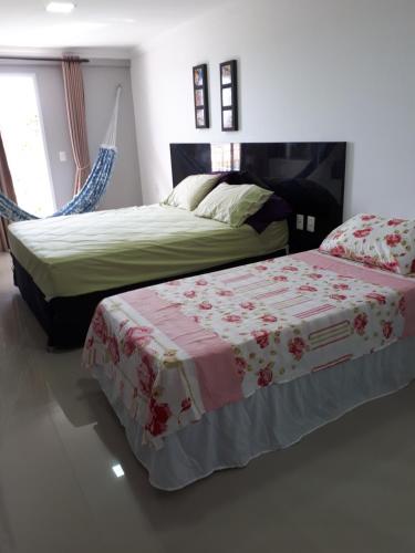 two beds in a bedroom with a bedskirts at Condomínio Solarium Residence in Aquiraz