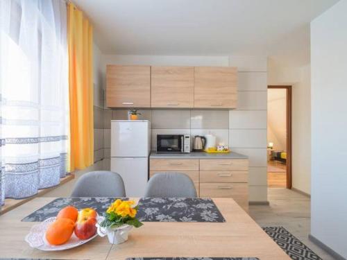 a kitchen with a table with a plate of fruit on it at Apartamenty Lejówka in Chochołów