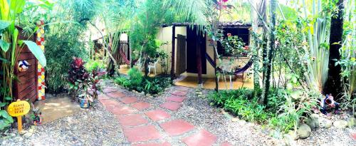a garden with a brick walkway in front of a house at Hotel Tropical Sands Dominical in Dominical