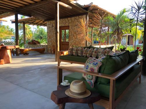 a green couch with a hat on a patio at Ocacocar - Milagres in São Miguel dos Milagres