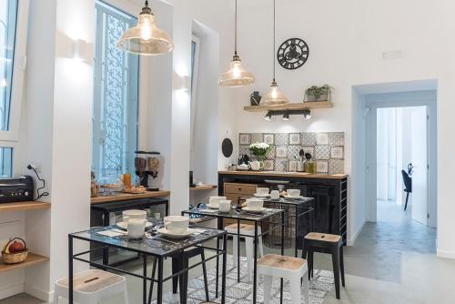 una cucina con due tavoli, sedie e bancone di A Misura Duomo Rooms & Apartment - LS Accommodations a Napoli