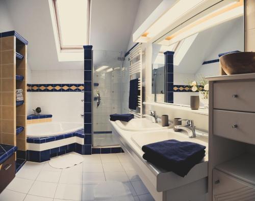ein Badezimmer mit zwei Waschbecken, einer Badewanne und einem Tubermott in der Unterkunft Postwirt Annaberg in Annaberg im Lammertal