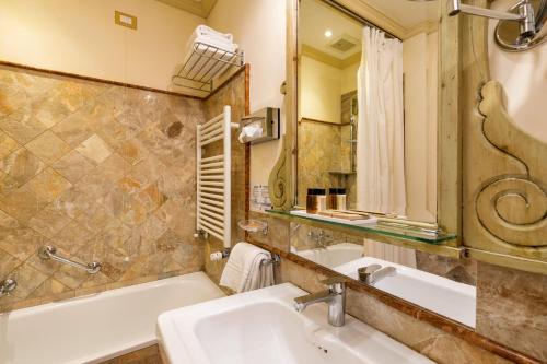 a bathroom with a tub and a sink and a bath tub at Hotel Villa Laguna in Venice-Lido
