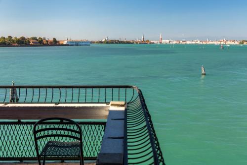 a bench sitting on a pier next to the water at Hotel Villa Laguna in Venice-Lido