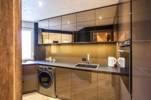 a kitchen with a washing machine and a sink at Bella Roe Premium Apartments in Belgrade