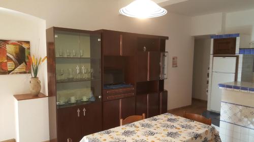 卡爾博尼亞的住宿－Casa Stella Marina，厨房配有桌子和带玻璃器 ⁇ 的橱柜