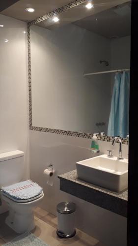 y baño con lavabo, aseo y espejo. en Casa More en Salta