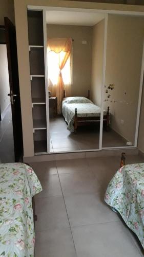 Dormitorio con espejo reflejo de cama en Casa More en Salta