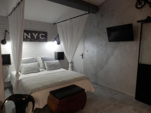 a bedroom with a bed and a television in a room at Mas les vieux chênes in Lambesc