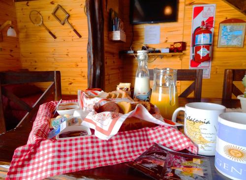 a table with a plate of food and a cup of orange juice at Cabañas Alechen in El Calafate