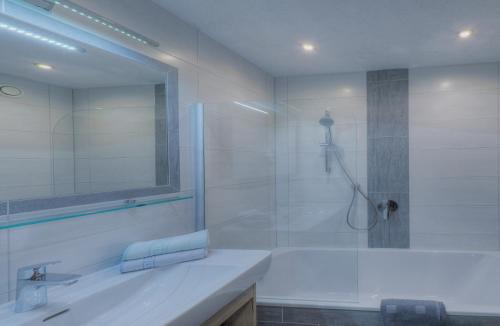 a bathroom with a tub and a sink and a shower at Landhaus zum Griena in Mayrhofen