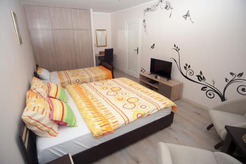 una piccola camera con due letti e una televisione di Park Apartman a Arandjelovac