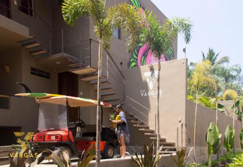 a woman standing in front of a building with a golf cart at Villa Vargas Sayulita in Sayulita