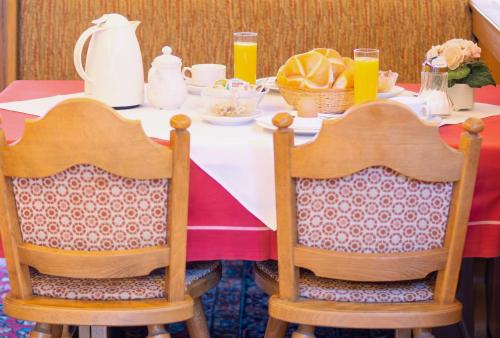 two chairs at a table with a red and white table cloth at Landhaus zum Griena in Mayrhofen