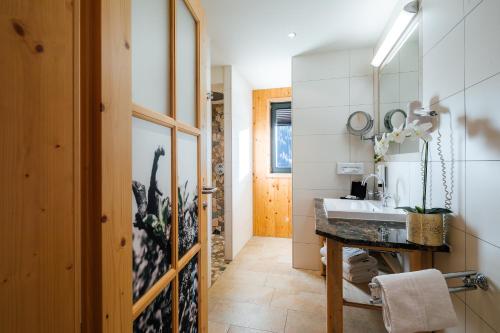 een badkamer met een wastafel en een spiegel bij Hotel Gipfelherz Ischgl in Ischgl
