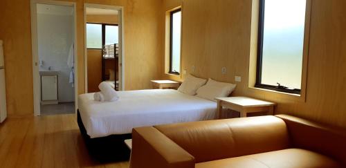 um quarto de hotel com uma cama e um sofá em Bimbi Park - Camping Under Koalas em Cape Otway