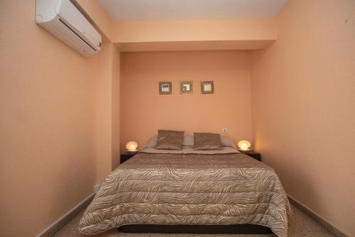 a bedroom with a bed with two pillows on it at Apartamento cómodo a 10 min del centro in Alicante