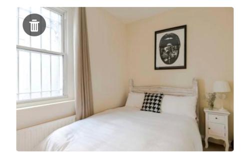 a bedroom with a white bed and a window at The Pink House in London