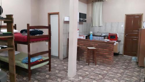 een kamer met een bed en een keuken bij Suíte ampla com cozinha Ibitipoca in Conceição da Ibitipoca
