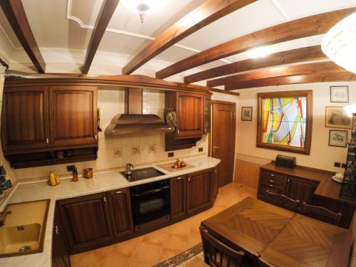 a kitchen with wooden cabinets and a stained glass window at DB Apartment in Tirana
