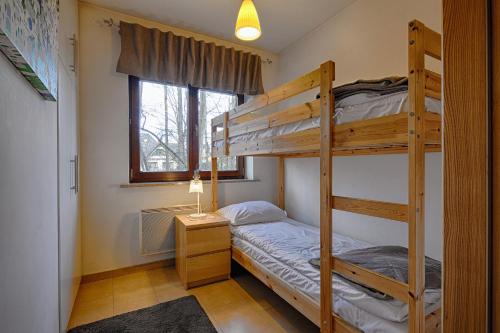 a bedroom with two bunk beds and a window at Rubin Apartamenty Mozaika centrum taras in Zakopane