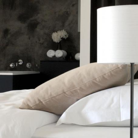 a bedroom with a bed with a pillow and a lamp at Moulin Renaudiots - Maison d'hôtes in Autun