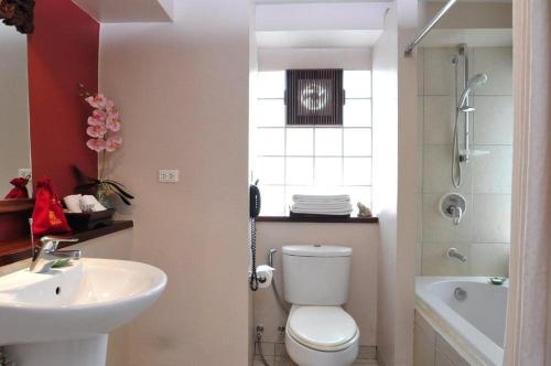 a bathroom with a toilet and a sink and a shower at The Siam Heritage Hotel in Bangkok